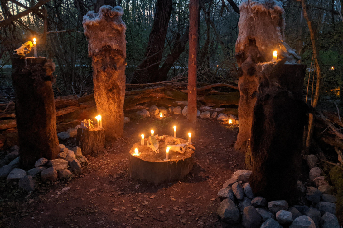 A forest ritual circle at dusk, surrounded by fur-draped wooden effigies and glowing candlelight. A central stump altar holds bones and flame, evoking ancient Norse ceremony and sacred stillness.