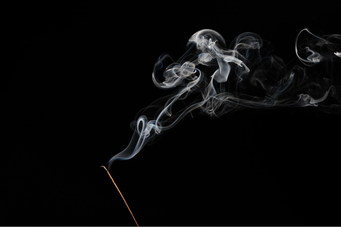 Natural incense stick burning in darkness, releasing a soft spiral of smoke—symbolizing mindful ritual, Norse tradition, and elemental transformation.