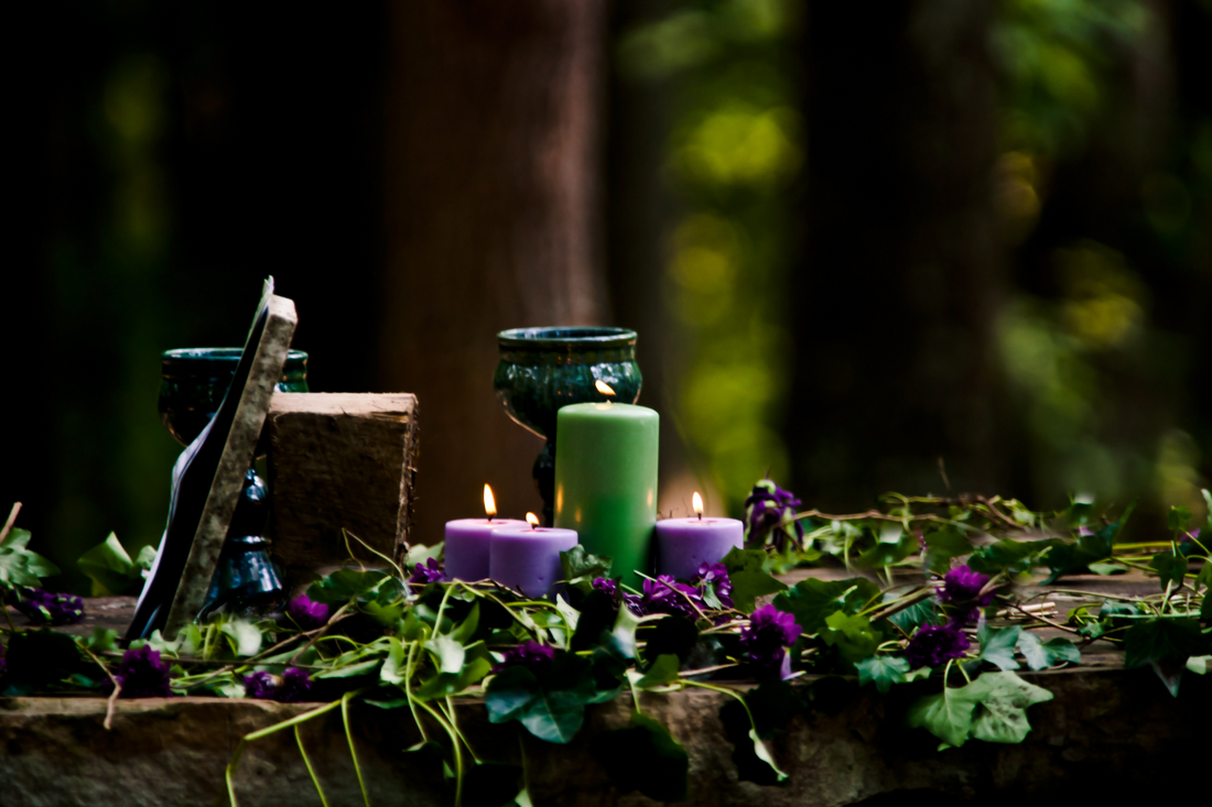 Forest altar adorned with candles, herbs, and ritual tools, symbolizing a Norse-inspired sacred space for meditation and spiritual practice.